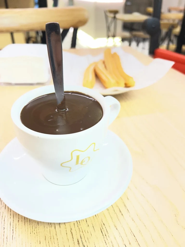 Taza de chocolate a la taza espeso con churros en la Churrería La Quinta, un sitio donde desayunar en Santiago de Compostela