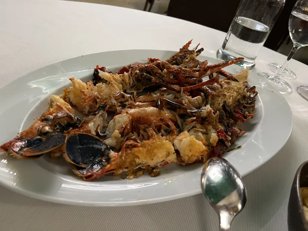 Langosta entera a la brasa servida en fuente blanca en un restaurante de Santiago de Compostela