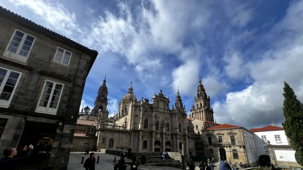 Fachada norte de la Catedral de Santiago de Compostela vista desde la Plaza de la Inmaculada con visitantes en primer plano