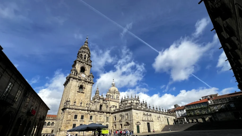 Plaza de la Quintana de Santiago de Compostela con la torre del reloj de la Catedral y terraza de café en primer plano