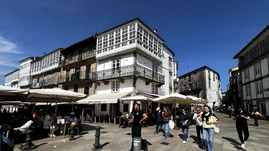 Terrazas en la Porta Faxeira de Santiago de Compostela con edificios de galerías típicas gallegas al fondo