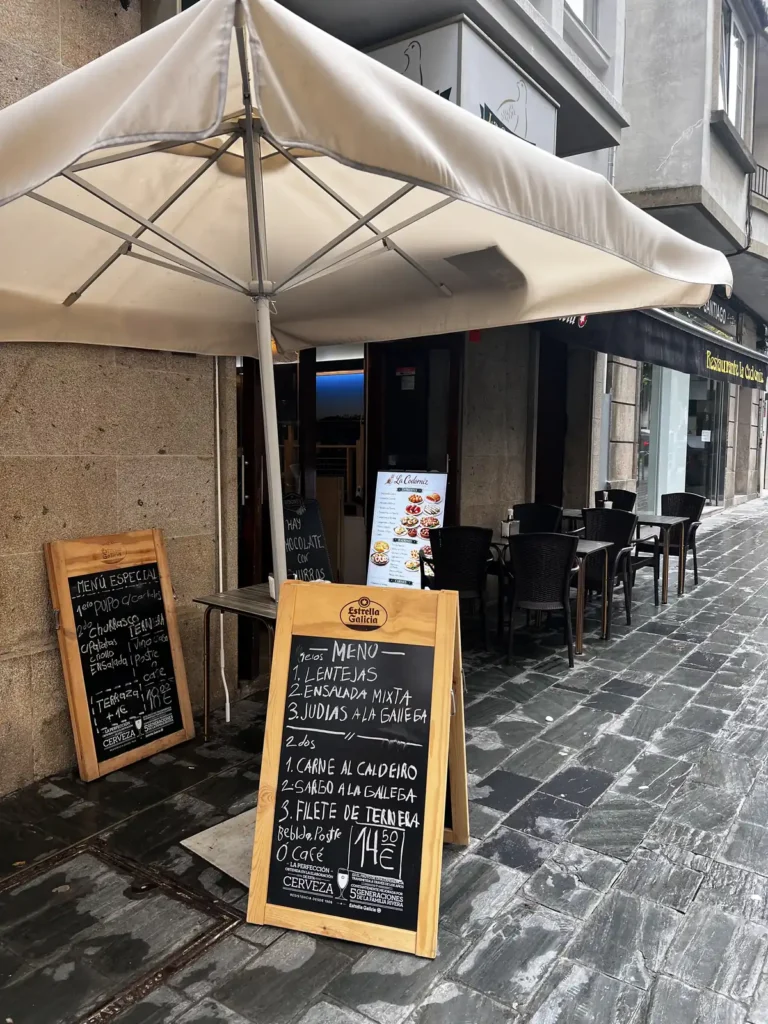 Pizarras con el menú del día de La Codorniz en Santiago de Compostela: lentejas, ensalada mixta o judías a la gallega de primero; carne al caldeiro, sargo a la gallega o filete de ternera de segundo, bebida, postre o café por 14,50€